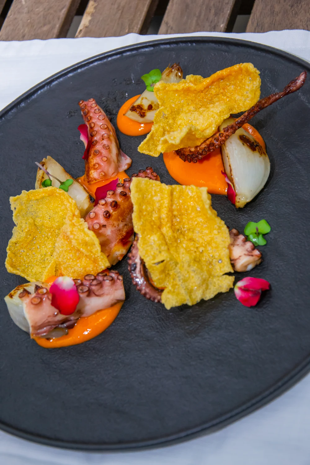 Polpo Scottato Con Cipolla Bianca Infornata, salsa di Peperoni e chips di Riso al Curry