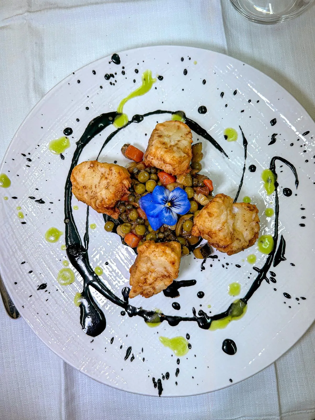 Baccalà in pastella su verdure saltate e nero di seppia